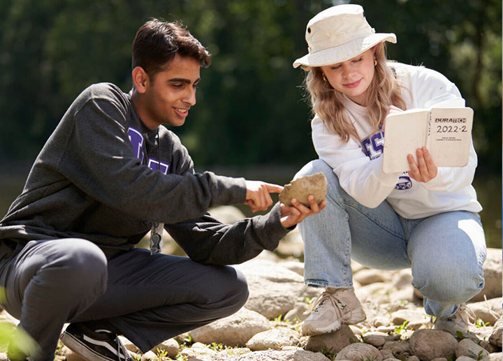 Students analyzing river rocks outside